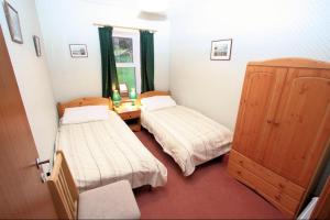 a small room with two beds and a window at Cove Cottage Ellary in Lochgilphead