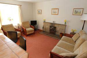 a living room with a couch and a fireplace at Cove Cottage Ellary in Lochgilphead