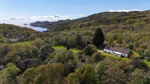 an aerial view of a house on a hill next to the water at Cove Cottage Ellary in Lochgilphead