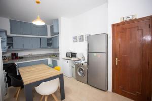 a kitchen with a table and a refrigerator at Apartamento en Residencia Brooks Iberia in Tangier