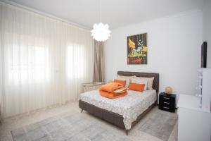 a bedroom with a bed with an orange blanket on it at Apartamento en Residencia Brooks Iberia in Tangier
