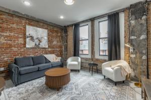 a living room with a couch and a brick wall at Park Hotel 2BR Suite 306 in Chattanooga