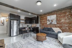 a living room with a couch and a brick wall at Park Hotel 2BR Suite 306 in Chattanooga