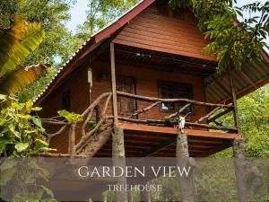 a small wooden house with a treehouse sign in front of it at Treehouses Yao Noi in Ko Yao Noi