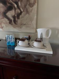 a white shelf with two plates and a painting at Cross Hands Hotel in Llanybyther +22 photos