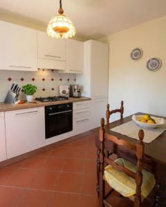 a kitchen with white cabinets and a table with a bowl of fruit at Casa Corbella in Magnano