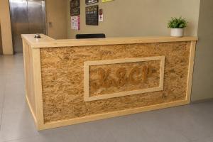 a wooden reception counter with a sign on it at Ain Studio Apartment in Kota Bharu
