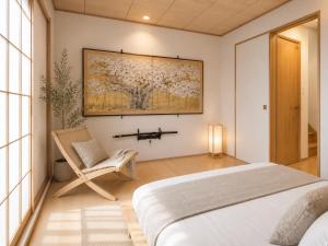 a bedroom with a bed and a chair and a painting at 渋谷駅徒歩10分!!一棟まるごと貸し切り!お子様歓迎駐車場無料10人ok5部屋バスルーム2つ in Tokyo