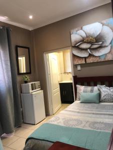 a bedroom with a bed and a painting on the wall at Golf View Lodge Melmoth in Melmoth