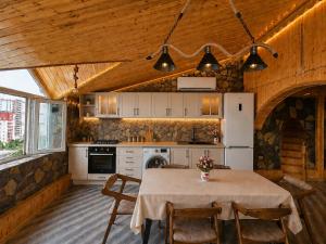 a kitchen with a table with chairs and a kitchen with white cabinets at Ganja Comfort Home in Ganja