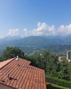 a red tile roof with mountains in the background at Casa Corbella in Magnano +1 photo