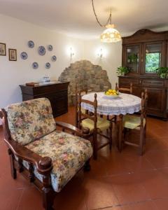 a dining room with a table and chairs and a stone fireplace at Casa Corbella in Magnano