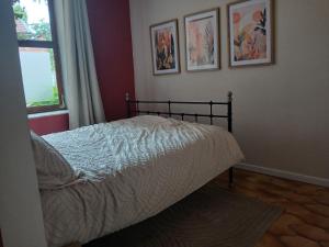 a bed in a bedroom with pictures on the wall at Sur l'Oneux in Hotton