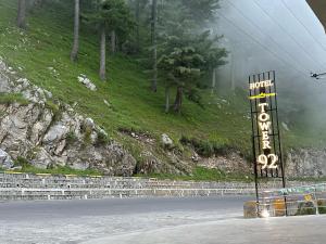 a sign on the side of a road next to a mountain at Tower 92 - Hotel in Ghora +12 photos