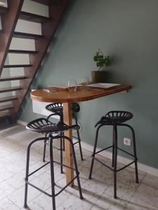 a table and two stools with wine glasses on it at Sur l'Oneux in Hotton