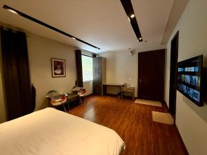 a bedroom with a bed and a desk and a table at Tower 92 - Hotel in Ghora