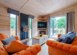 a living room with orange furniture and a large window at Ashlea Pools Lodges in Hoptonheath +52 photos