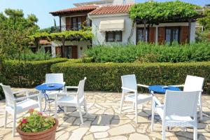 a patio with chairs and tables and a house at Jasmine apartments in Pythagoreio
