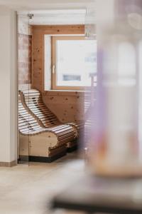 a wooden bench in a room with a window at FIRSTpeak Zauchensee in Zauchensee +36 photos