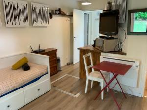 a bedroom with a bed and a desk and a table at Studio Tennis Riviere in Annecy