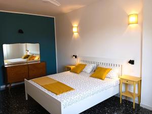 a bedroom with a bed with yellow pillows and a mirror at CASA IUCCI Langhe Monferrato in Canelli