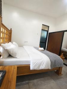 a bedroom with a large bed with white sheets and pillows at Boma Retreat in Boma la Ngombe