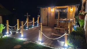 a wooden deck with ropes and a cross and a church at Domy na Spiszu in Czarna Góra
