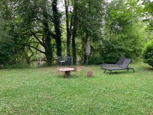 a garden with a bench and a chair and an umbrella at Studio Tennis Riviere in Annecy +6 photos