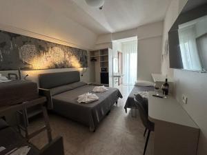 ein Wohnzimmer mit zwei Betten und einer Couch in der Unterkunft Hotel DOLCEVITA Park & Beach included in Lido di Jesolo + 71 Fotos