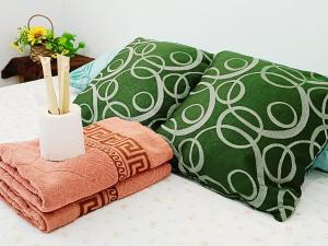 ein Stapel Decken und Kissen auf einem Bett in der Unterkunft Amigas Transient in Santo Tomas