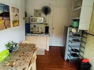eine Küche mit einem Tisch und eine Küche mit einem Kühlschrank in der Unterkunft Amigas Transient in Santo Tomas
