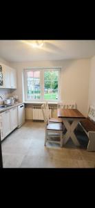 a kitchen with a wooden table and a table and chairs at Dom Na Fali in Pasym +9 photos