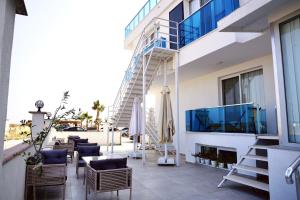 a patio with chairs and a staircase on a building at Koi otel in Ayvalık