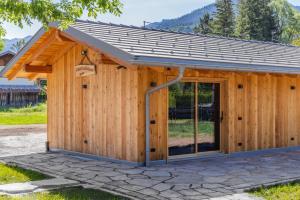 a wooden building with a large glass door at Shasta Mountain Lodge in Cavalese