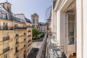 a balcony in a building with a table and chairs at Hôtel Oratio in Paris