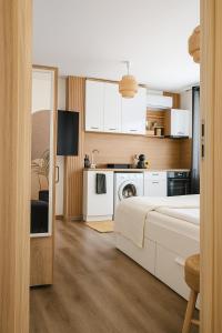 a bedroom with a white bed and a kitchen at Panorama Sunset Studio in Stara Zagora