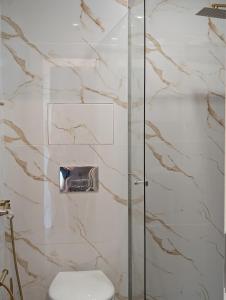 a bathroom with a glass shower with a toilet at Panorama Sunset Studio in Stara Zagora