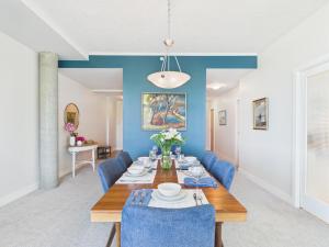 a dining room with a table and blue chairs at Panoramic Ocean & Fairway Views At Sayward Hill in Victoria +30 photos