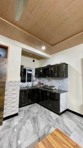 a large kitchen with black cabinets and marble floors at 1 Bed Apartment with View in Patriata