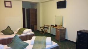 a hotel room with two beds and a mirror at Hotel Corneliuss in Galaţi