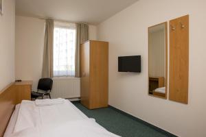 a hospital room with a bed and a mirror at Hotel Kanarek in Prague