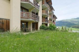 a building on a hill with a field of grass at Les Cimes - La Canopée in Gresse-en-Vercors