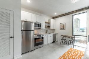 a kitchen with a stainless steel refrigerator and a table at Park Hotel Studio Suite 507 in Chattanooga