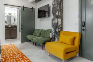 a living room with a yellow chair and a mirror at Park Hotel Studio Suite 507 in Chattanooga