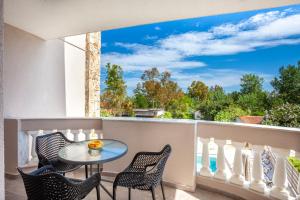 a patio with a table and chairs on a balcony at Villa Olia with private pool in Pefkochori
