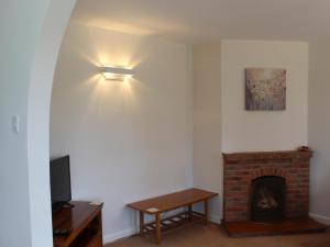 a living room with a fireplace and a light at Castle House Cottage in Horton
