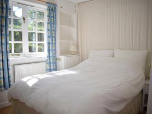 a white bed in a bedroom with a window at Castle House Cottage in Horton +4 photos