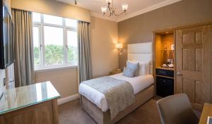 a bedroom with a bed and a desk and a window at FERRY HOUSE stranraer in Stranraer