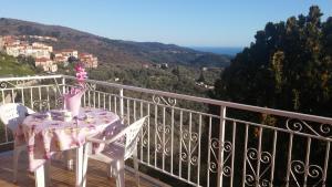 Villa FaraldiにあるAppartamenti Varaldo & Elena CITR 008O67のピンクのテーブルと椅子付きのバルコニー