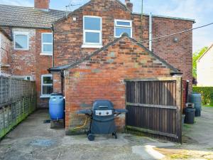 a brick house with a stroller in front of it at Billada Cottage in Firsby